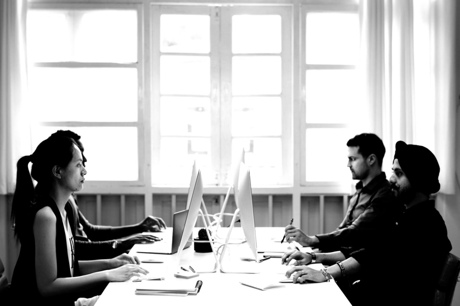 Finance professionals reviewing investment portfolios and regulatory compliance documents in a modern Belgian office setting